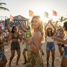 Load image into Gallery viewer, The Rich Oil Atomic Oil natural sun maximizer tanning oil bottle held by a smiling woman at a beach festival.
