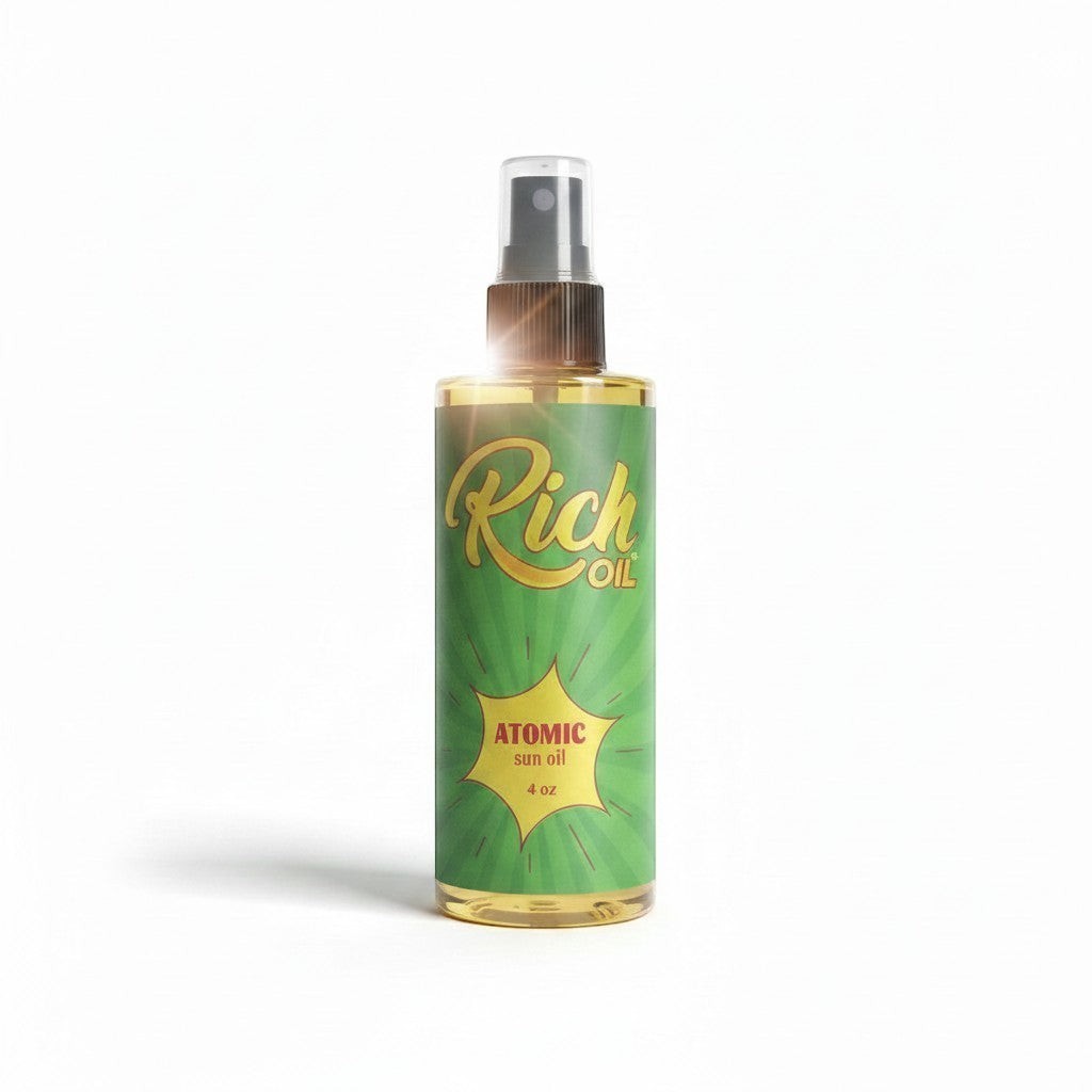 The Rich Oil Atomic Sun Maximizer Tanning Oil in a clear spray bottle with a green label featuring yellow sunbursts and gold lettering.