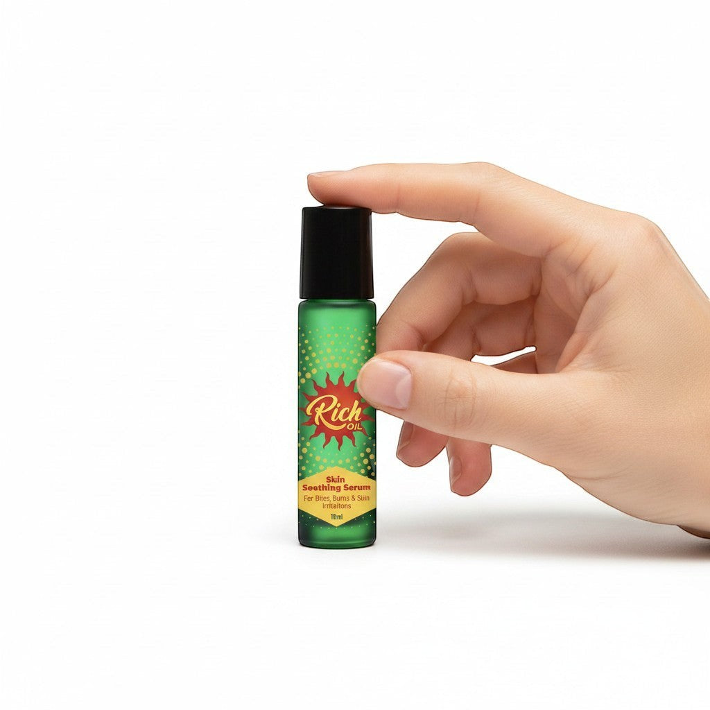 The Rich Oil natural skin soothing serum in a green rollerball bottle with a black cap, held by a hand.